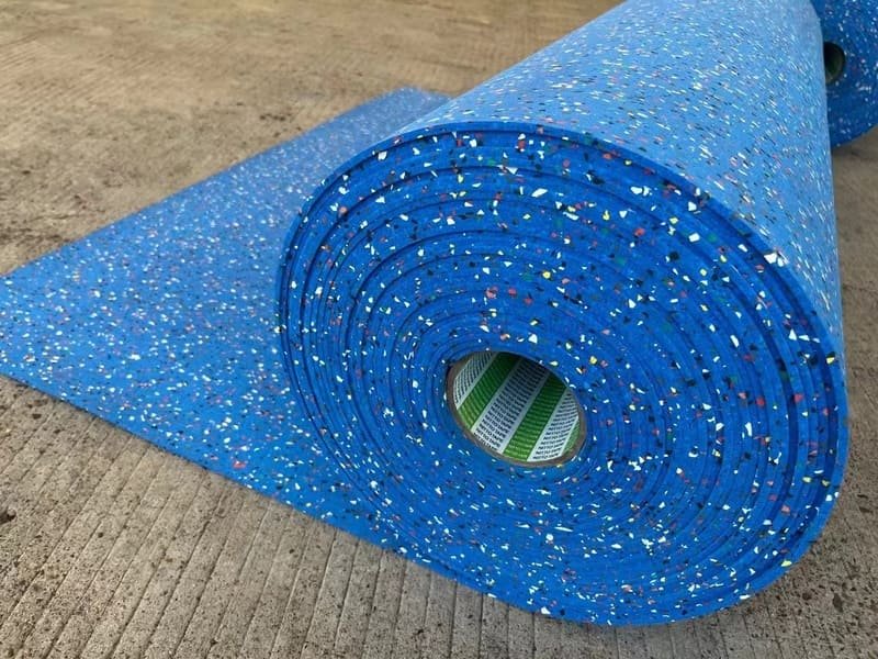 A professional installer applying specified adhesive for rubber roll flooring